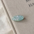 Detailed close-up of oval mint green acetate hair clip with sparkling rhinestones - Light Blue