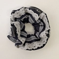 Dettaglio di un elastico nero con bordo in pizzo a contrasto e trama plissettata retrò - Elastico a Righe Blu