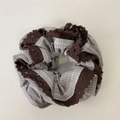 Dettaglio dell'elastico per capelli a quadretti grigi con bordo in pizzo marrone - Elastico a Righe Grigie