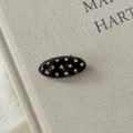 Détail macro d'une barrette ovale en écaille de tortue sertie de strass brillants - Écaille