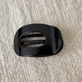 Detail view of a black glossy oval hollow hair claw clip with a sleek piano finish - Black Hollow Duckbill Clip