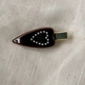 Detailed close-up of brown acetate hair clip with rhinestone heart on linen background - Brown