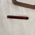 Détail d'une barrette faite main en acétate ambre avec inscription dorée France et métal - Marron