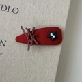 Dettaglio molletta per capelli rossa con fiocco a righe e stella blu su tela beige - Clip BB a Maglia Stella