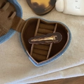 Braune gewellte Haarspange aus Acetat mit goldenem France-Etikett auf Denim-Box - Dunkelkaffee