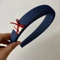 Detail showing the denim texture, red bow, and handmade label on the navy headband - Blue Headband
