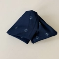 Dettaglio dell'elastico per capelli in tessuto blu navy con motivo geometrico a stelle - Triangolo