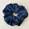 Dettaglio dello scrunchie floreale blu scuro con motivi a stella e trama pieghettata - Scrunchie