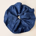 Dettaglio ravvicinato dell'elastico scrunchie blu a fiori con pieghe morbide e cuciture fini - Elastico Oversize