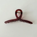 Dettaglio della molletta per capelli rosso vino trasparente con robusta molla in metallo - Incrociato