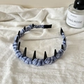 Dettaglio del cerchietto in tessuto scozzese blu con punte nere su lino bianco - Stile Scozzese Blu Chiaro con Rivetti a Punta