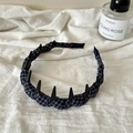 Dettaglio del cerchietto in tessuto scozzese antiscivolo con denti neri su lino bianco - Stile Scozzese Blu Scuro con Rivetti a Punta