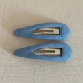 Detail of two light blue fabric-covered BB hair clips with silver metal inner snaps - Light Blue
