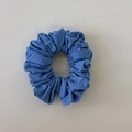 Close-up of a blue fabric scrunchie with soft pleated texture for hair styling - Light Blue