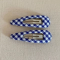 Detail of blue and white gingham fabric snap clips with metallic internal structure - Blue Plaid