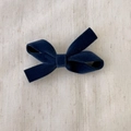 Detail showing the rich texture of the deep blue velvet bow hair clip with soft lighting - Blue