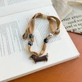 Detailed close-up of champagne silk scarf necklace with a brown dachshund dog pendant - Brown