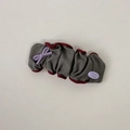 Detail showing grey pleated fabric hair scrunchie with red trim and purple resin bow - Gray Snap Clip