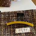 Macro shot of yellow velvet claw clip on tweed fabric with high texture detail - Yellow