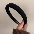 Gros plan du serre-tête rembourré noir montrant l'étiquette tissée Hand Made - Noir