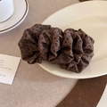 Macro shot of vintage leopard print bubble scrunchie on a white ceramic plate decoration - Dark Coffee
