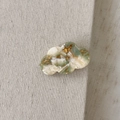 Detail view of cloud-shaped acetate hair clip with green marble texture and gold lettering - Ink Wash Green