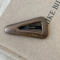 Detail of triangle BB clip with bronze snakeskin texture on a canvas book background - Champagne Gray Large Triangle Style