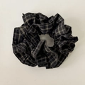 Detailed view of black and white checkered fabric scrunchie with soft pleated texture - Black Houndstooth