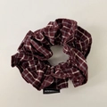 Detail view of double-layer plaid scrunchie with a handmade woven label in wine red - Reddish Brown Plaid