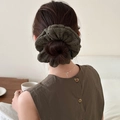 Macro shot of olive green knitted scrunchie showing detailed hollow stitch texture - Green