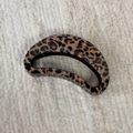 Dettaglio di un grande fermaglio per capelli leopardato su una base di tessuto morbido - Stile a Semicerchio Vuoto