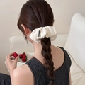 Detailed knit texture of a cream white oversized scrunchie worn on a ponytail - White