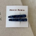 Dettaglio di due fermagli per capelli in acetato blu scuro con trama marmorizzata su carta - Blu Notte