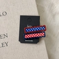 Detailed view of two checkered acetate hair clips on display card with wave edges - Red and Blue Series