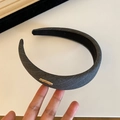 Detailed side view of dark grey striped fabric headband with rectangular gold metal accent - Striped Headband