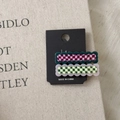 Detail view of two wavy checkered hair clips in purple and green with gold accents - Green System