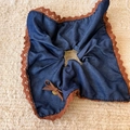 Dettaglio di elastico per capelli in denim blu con pizzo marrone e ciondolo dorato - Bandana