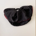 Gros plan d'un accessoire à pois noir et rouge avec une boucle ronde pour les cheveux - Pince à Cheveux Noire