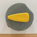 Detalle de una pinza para el pelo amarilla brillante en forma de gota sobre tela denim - Amarillo