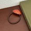Close-up of amber resin stone on vintage elastic hair tie with gold handmade lettering - Orange