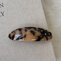 Detail of tortoise shell acetate hair clip with black bow and opal-like stone embellishment - Light Leopard