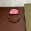 Detail of pink triangle hair tie with gold France Handmade text on dark wood surface - Pink