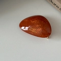 Dettaglio della molletta in acetato ambrato con scritta dorata France Handmade - Arancione