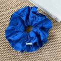 Détail d'un chouchou bleu marine surdimensionné à volants en coton avec étiquette de marque - Bleu