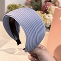 Detalle de una diadema ancha plisada azul con textura de rayas verticales y estilo retro - Azul