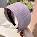 Detalle de diadema plisada lavanda con elegante textura de tela a rayas francesas - Morado