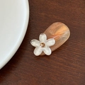 Vista macro di un fermaglio per capelli a fiore bianco opaco con strass su legno - Fiore Bianco Base Rosa Arancio