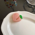 Vue détaillée d'une pince à cheveux pêche rose avec feuilles vertes et strass brillants - Pêche