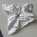 Close-up of white fabric hair scrunchie with colorful polka dots and cherry brand tag - Polka Dot Fabric Square Scarf