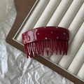 Detailed view of a vintage red acetate hair comb with sparkling multi-colored rhinestones - Red